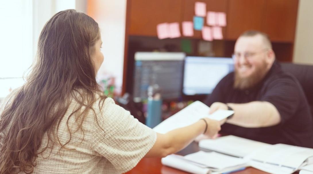 マネージャーから書類を受け取るインターン